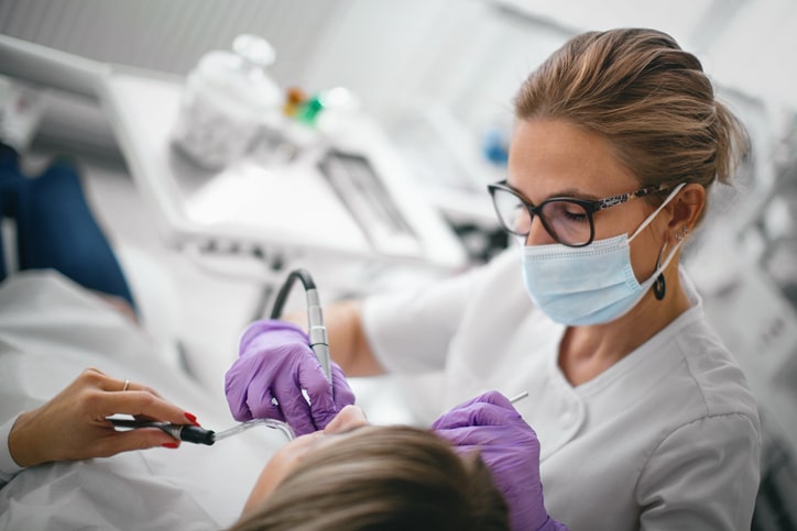 Dentist repairing the patient's teeth in the dental office.